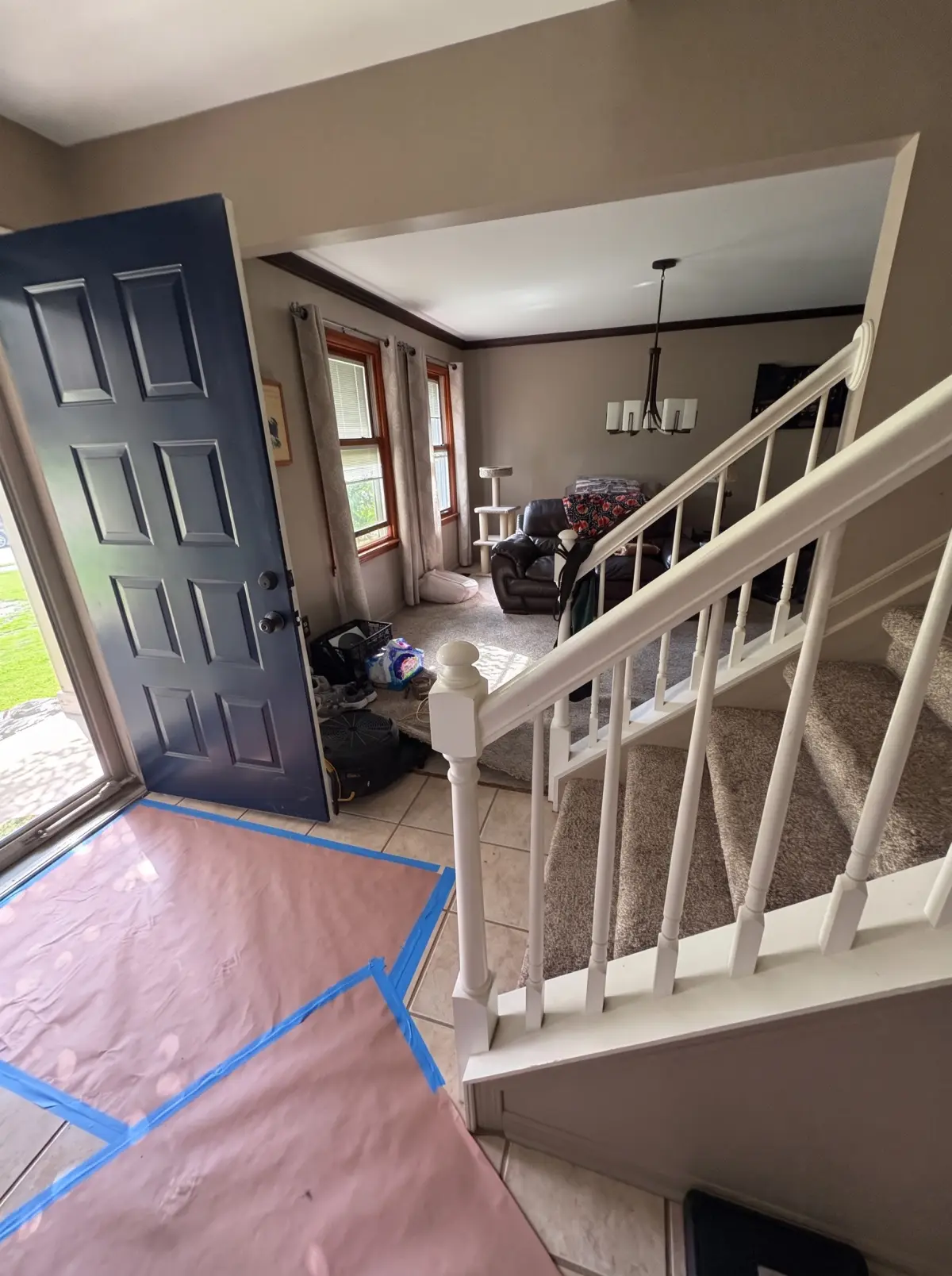 Front entry and staircase with floor protection taped down during a water damage job