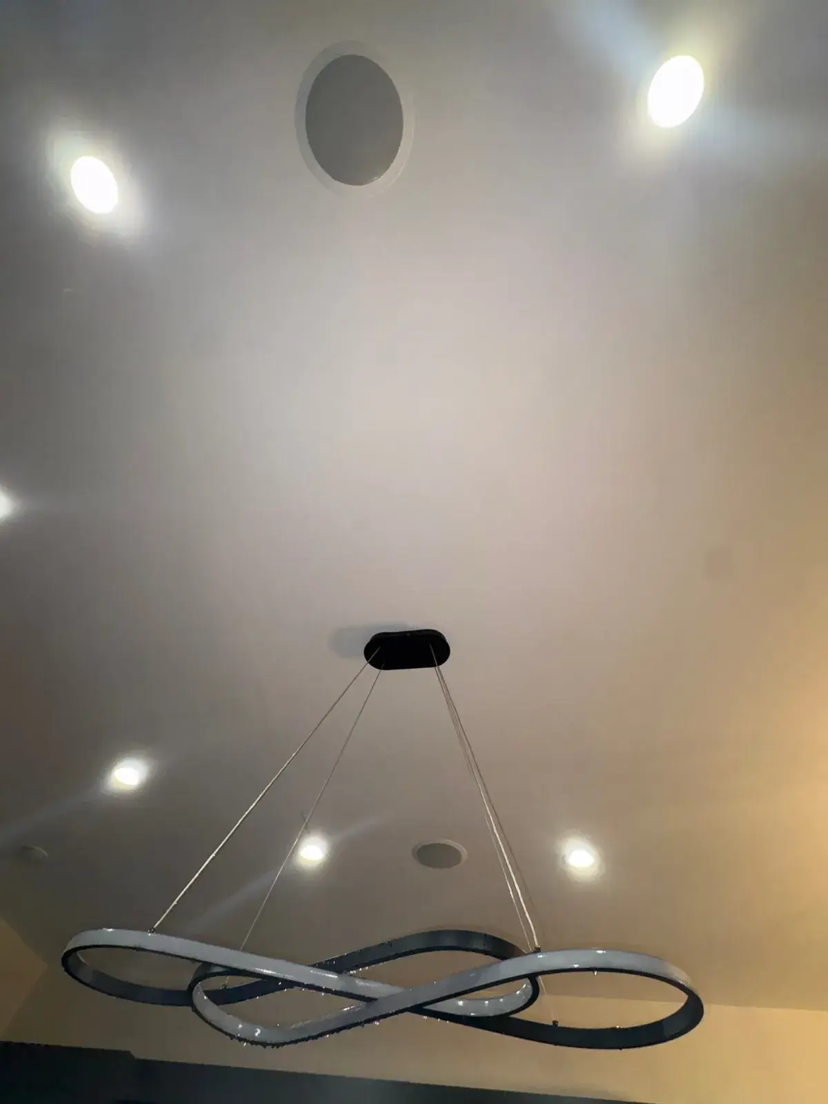 Finished ceiling with recessed lights and a pendant fixture after a roof leak repair