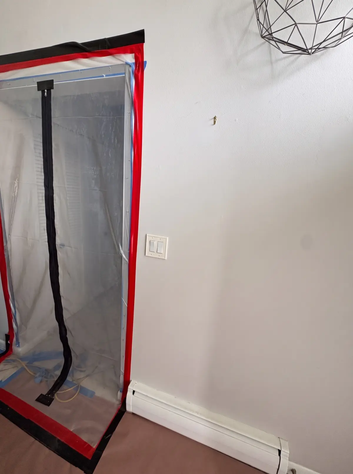 Plastic containment wall with a zip door sealing off a work area