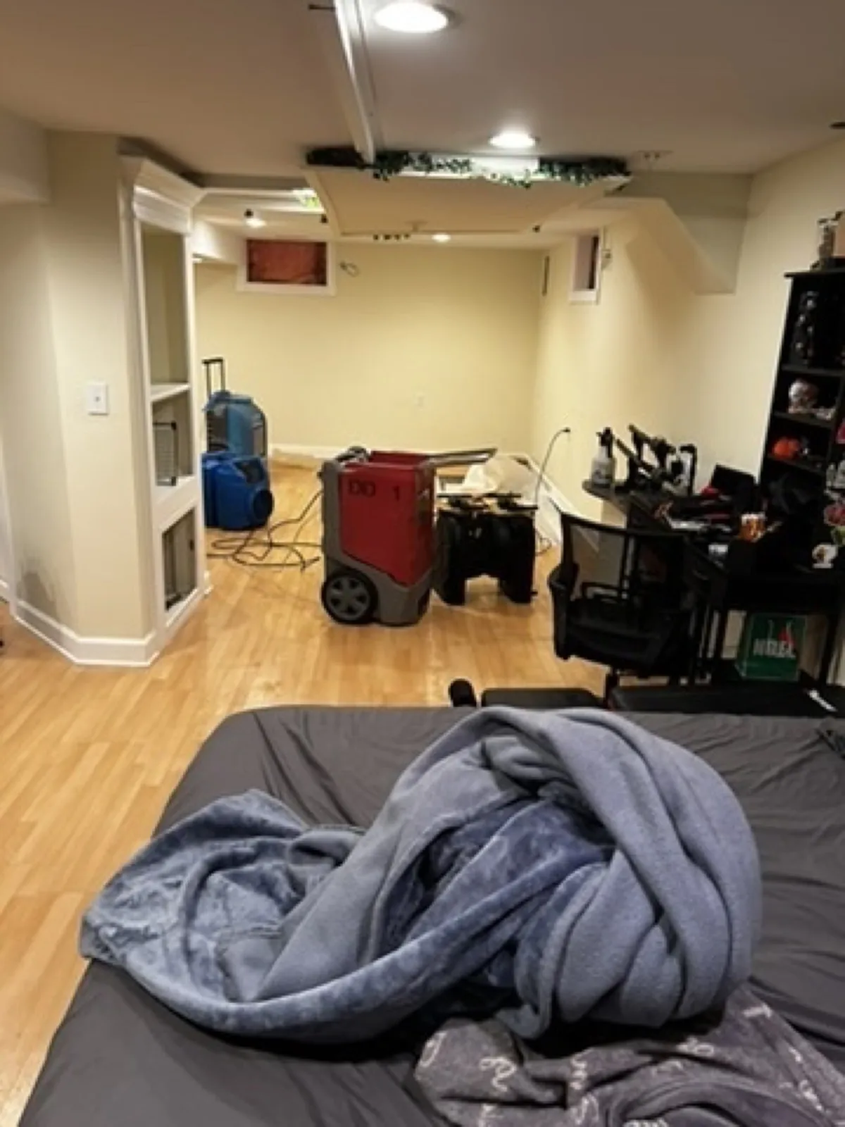 Basement room with a dehumidifier and drying equipment set up near a sitting area