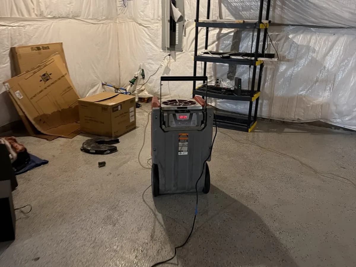 Dehumidifier drying a utility room after a leak, Troy job