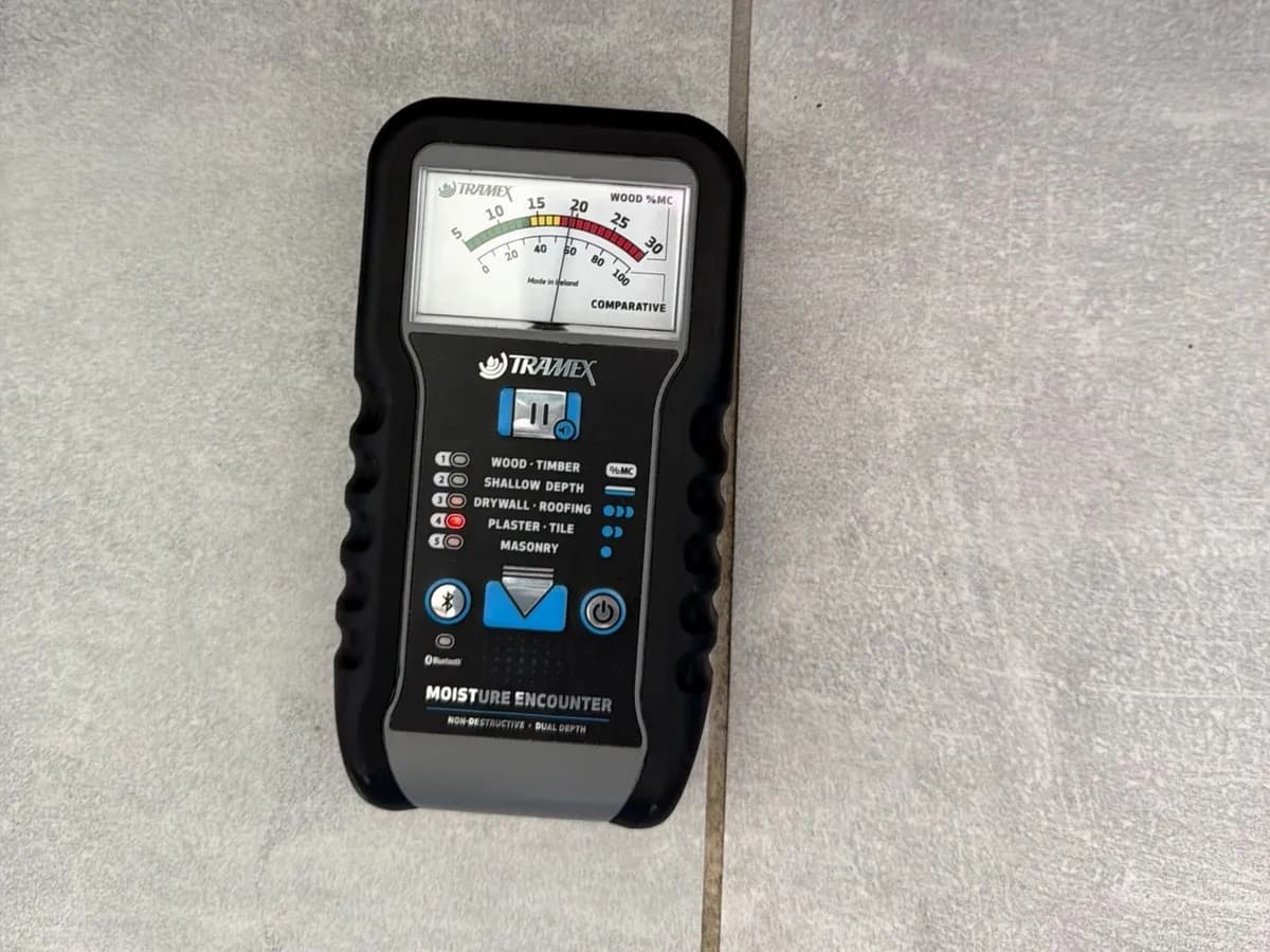 Moisture meter reading on a tile floor, Troy job