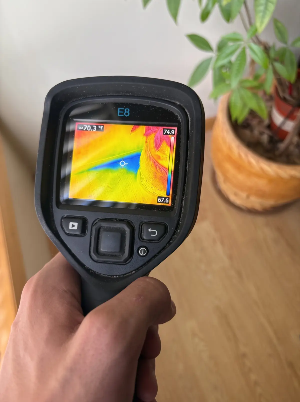 Thermal camera screen showing a cool moisture pattern during a water damage check