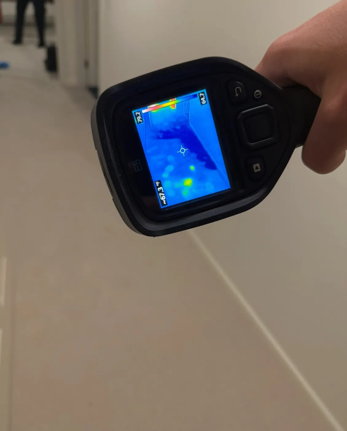 Thermal imaging camera showing a cool moisture pattern spreading behind a wall
