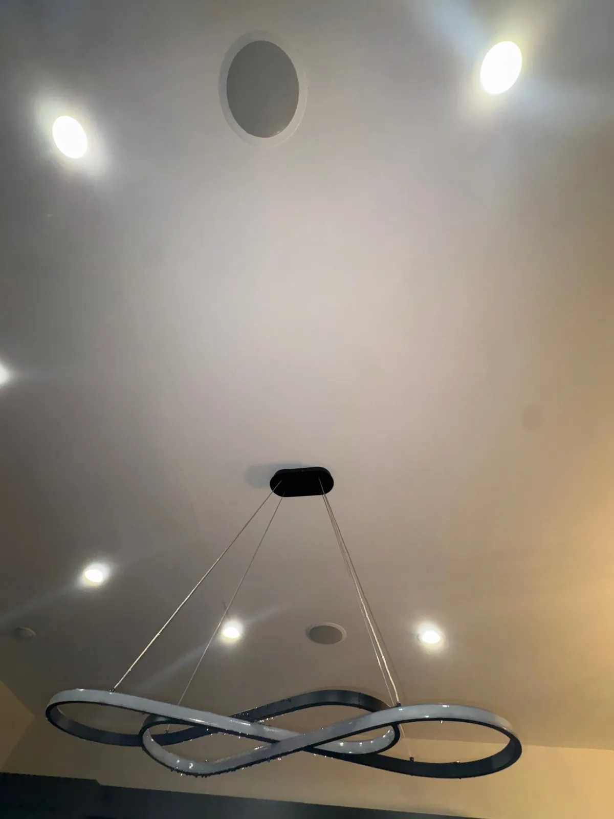 Finished white ceiling with recessed lights and a pendant fixture after a repair